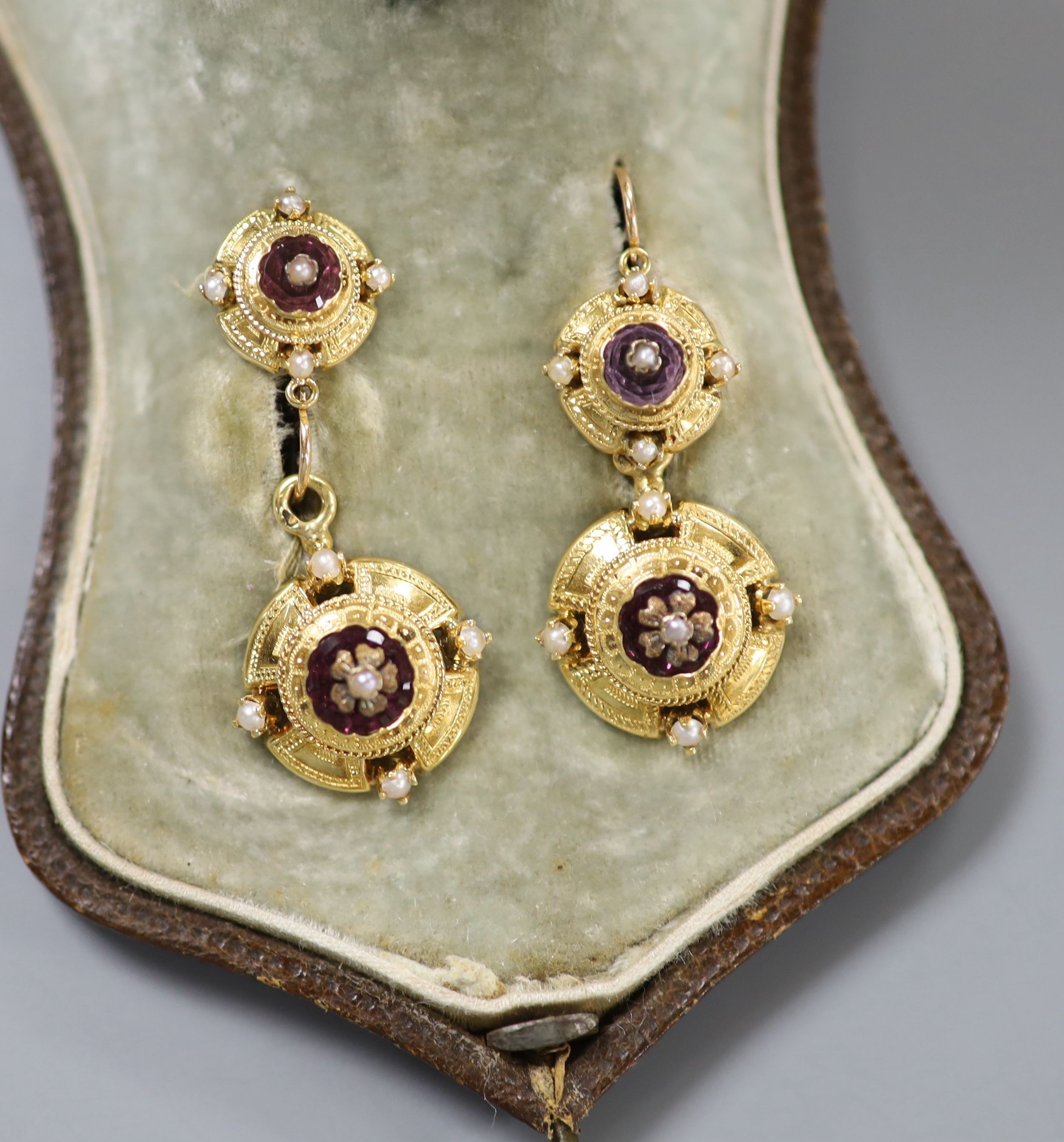 A cased continental Victorian style yellow metal, amethyst paste and seed pearl set demi parure, comprising a brooch and pair of matching earrings, brooch 35mm, earrings overall 37mm, gross weight 12.8 grams.